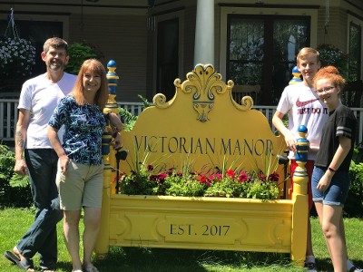 Happy Family Next to Victorian Manor Sign